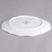 A white oval porcelain dish with a small design on it.