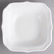 A white square bowl with a scalloped edge.