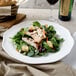A Villeroy & Boch white porcelain round platter with a salad of grilled chicken and croutons.