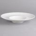 A white porcelain deep plate with a rim.