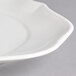 A close up of a Villeroy & Boch white porcelain oval flat plate with a curved rim.