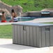 A grey Lifetime outdoor storage box on a concrete patio.