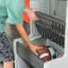 A boy putting a football into a Lifetime outdoor locker.