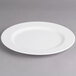 A white Villeroy & Boch porcelain plate with a rim on a gray surface.