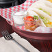 A table with a round raspberry deli server filled with tacos and salsa.