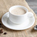 A white Villeroy & Boch porcelain cup of coffee on a saucer with a spoon.