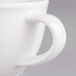 A white cup with a handle.