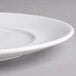 A close-up of a Villeroy & Boch white porcelain flat plate with a rim.