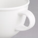 A close-up of a Villeroy & Boch white porcelain coffee cup with a handle.