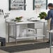 A man standing at a Regency stainless steel work table with a sink on the right.