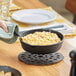 A person using a spatula to cook food in a Choice pre-seasoned cast iron skillet.