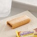A package of Nabisco Fig Newtons on a napkin next to a glass of water.