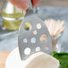 A person using a Franmara stainless steel cheese knife to cut cheese.