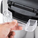 A person using the plastic handle on an Avantco 60 cup rice cooker.