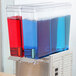 A Crathco refrigerated beverage dispenser with blue and red liquid containers.