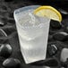 A Fineline clear plastic tumbler of water with ice and a lemon wedge.