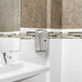 An Excel ThinAir hand dryer with brushed stainless steel cover above a white sink in a bathroom.
