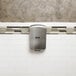 An Excel ThinAir high-efficiency hand dryer with a brushed stainless steel cover on a white tile wall.