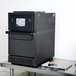 A black Merrychef eikon e2s countertop oven on a metal table.
