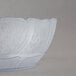 A clear polycarbonate bowl with a curved edge.