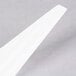 A close-up of a Fineline white plastic spoon.