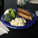 A Creative Converting Baltimore Ravens paper dinner plate with broccoli and cauliflower on it.