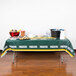 A Green Bay Packers plastic table cover on a table with food.