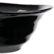 A close-up of a black Reserve by Libbey Pebblebrook bowl with a curved edge.