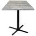 A Holland Bar Stool 36" square greystone table with a black cross base.