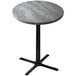 A round Holland Bar Stool outdoor counter height table with a grey stone top and metal base.