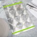 A Menu Solutions Alumitique menu board with a green band on a white surface with silverware.