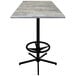 A Holland Bar Stool 36" square greystone table with a black foot rest base.