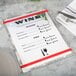 An Alumitique menu board with red bands on a table with a menu.