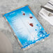 A Menu Solutions Alumitique menu board with royal blue bands on a table with a knife and fork on a napkin.