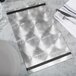 A silver Menu Solutions Alumitique menu board with black bands on a table with silverware and a white plate.