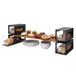 A black matte steel bakery display column with pastries on the shelves.