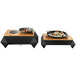 A Rosseto black matte steel chafer alternative warmer base holding two plates of food.