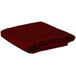 A folded burgundy rectangular table cover.
