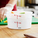 A person's hand in a white glove using a white Choice Polypropylene food storage container.