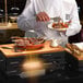 A chef using a Rosseto natural bamboo serving board to prepare food.