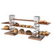 A Rosseto rectangular natural walnut narrow riser shelf holding pastries and muffins.