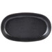 A black oval cast iron fajita skillet with a black rim.