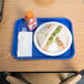 A blue plastic Choice fast food tray with a sandwich and a bottle of juice on it.