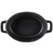 A black oval cast iron dish with handles.