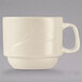 A close up of a Libbey cream white china cup with a handle.