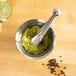 A Fox Run stainless steel mortar and pestle with lime wedges.