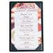 A black Menu Solutions wood board with picture corners on a table with a dessert menu.