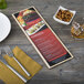 A customizable wood menu board on a table with a knife and fork and a picture of a burger.