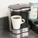 A Conair Cuisinart coffee maker with a cup of coffee on the counter.