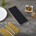 A customizable wood menu board with top and bottom strips on a wood table